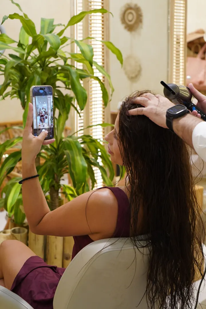 Cliente in salone che fotografa la piega con lo smartphone